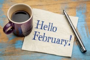 Hello February - handwriting on a napkin with a cup of coffee